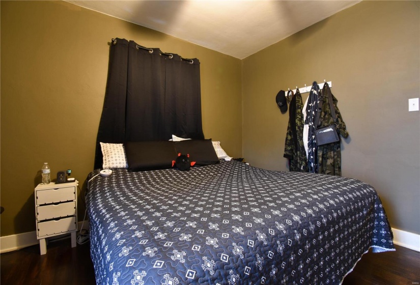 Bedroom featuring vaulted ceiling and dark hardwood / wood-style floors