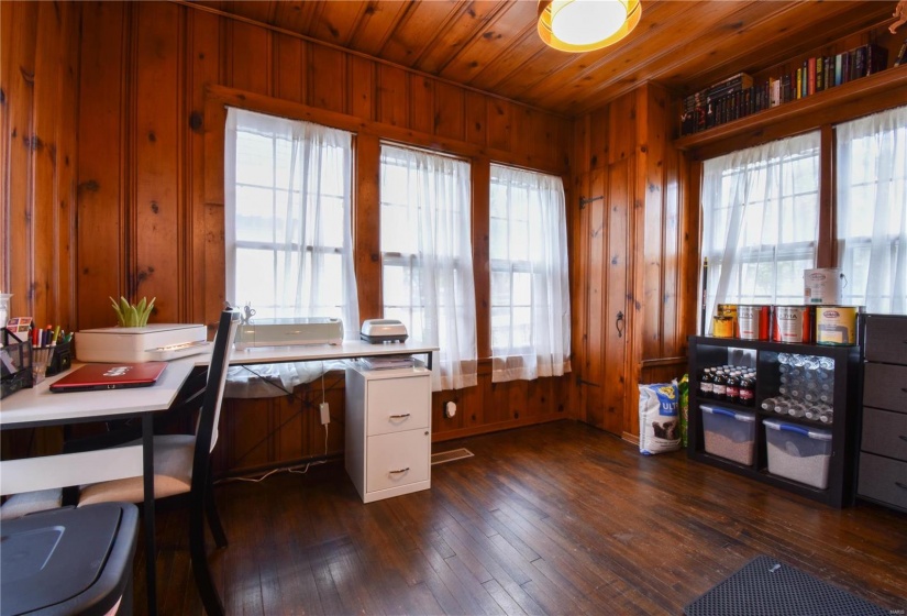 Office area with wood walls, dark hardwood / wood-style flooring, and a wealth of natural light