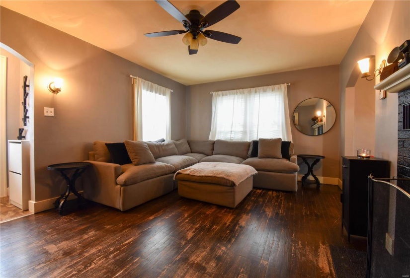 Living room with ceiling fan and dark hardwood / wood-style floors