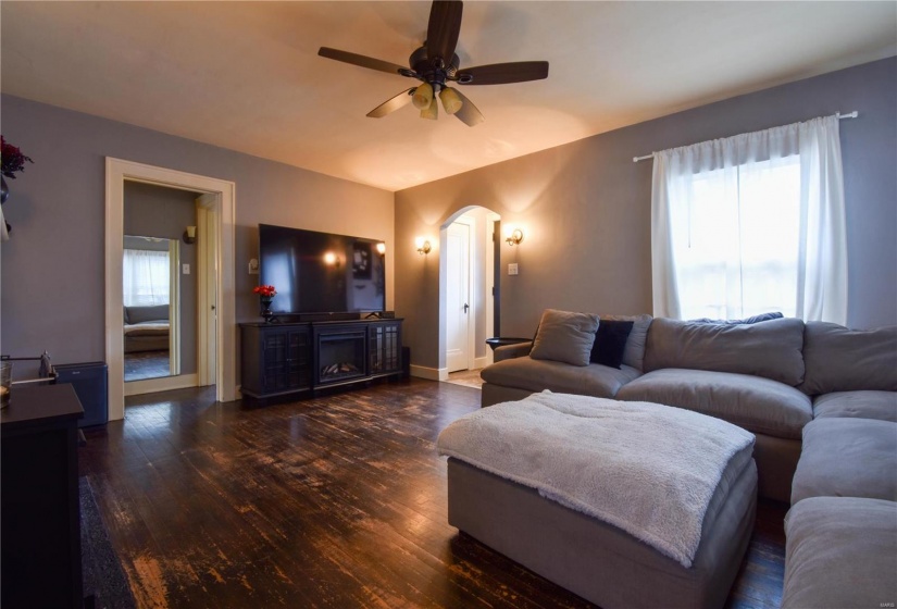 Living room featuring dark hardwood / wood-style floors, ceiling fan, and plenty of natural light